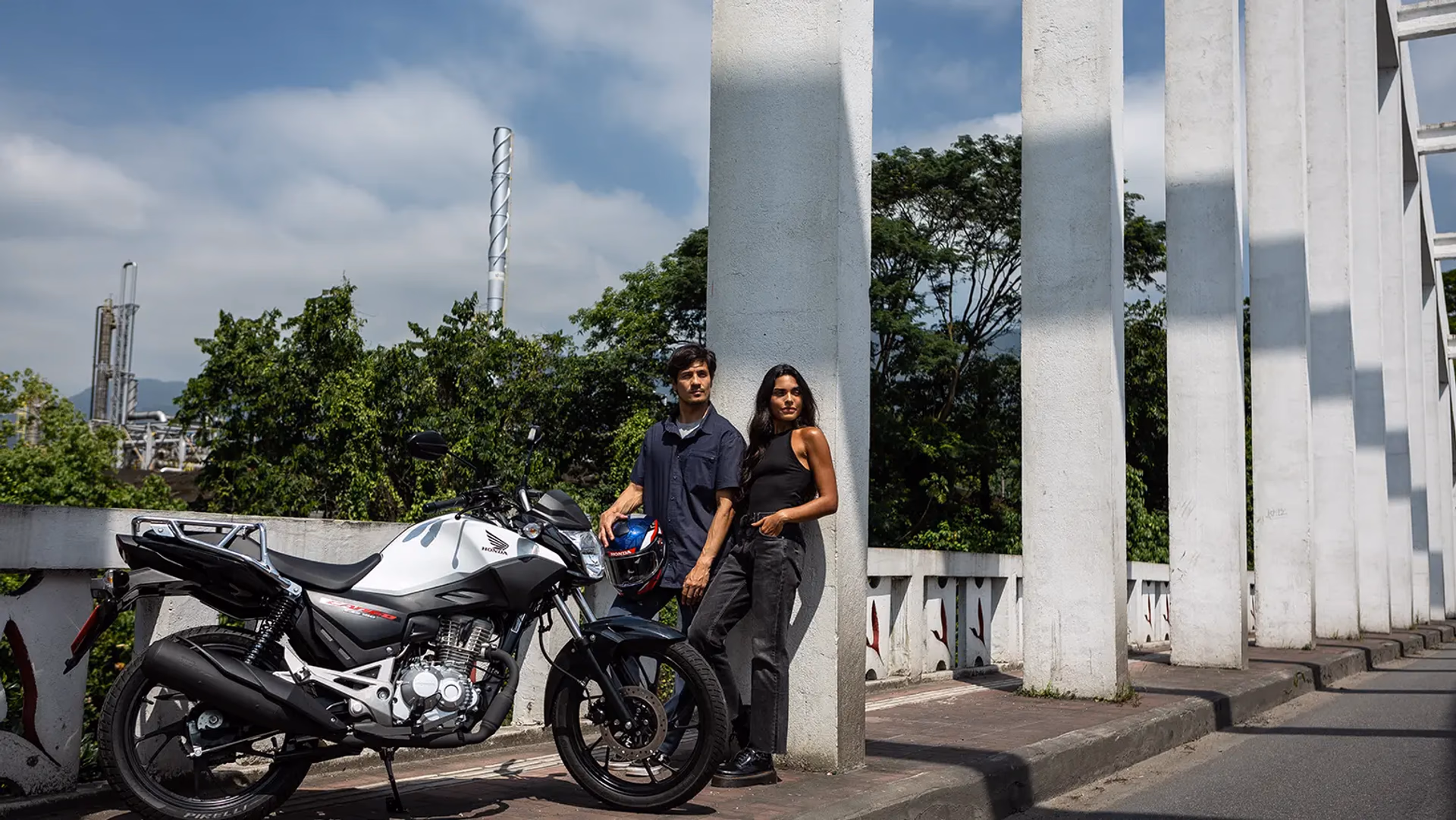 Casal olhando para o horizonte à frente da moto CG Cargo - 1 de 9